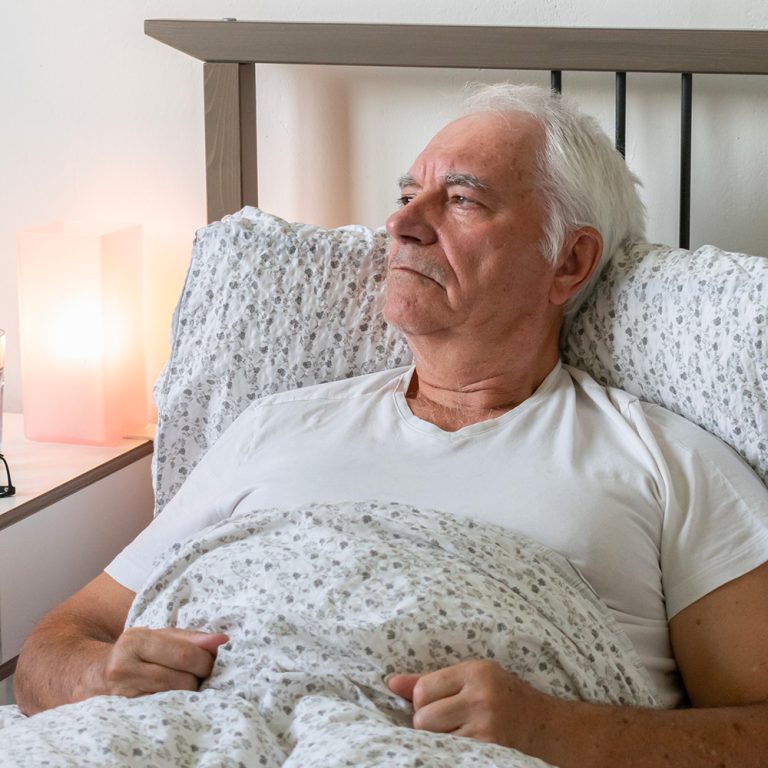 Old man looking through window